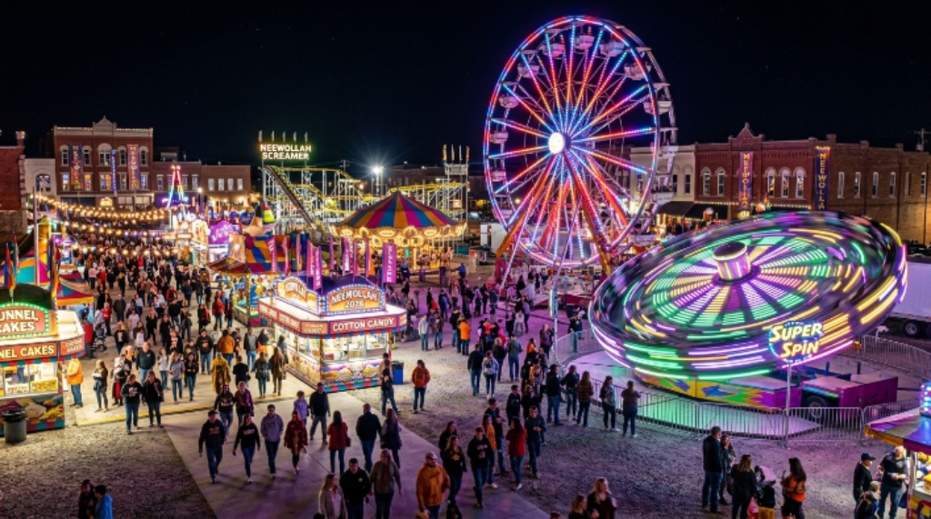 Carnival rides lit up at night on the Neewollah Festival 2026 grounds in downtown Independence Kansas during the nine-day October celebration